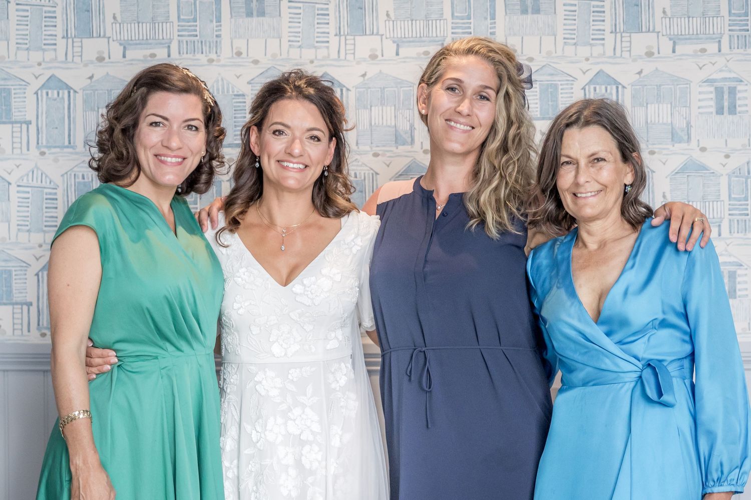 Group photo of wedding party wearing coordinated blue and green attire.