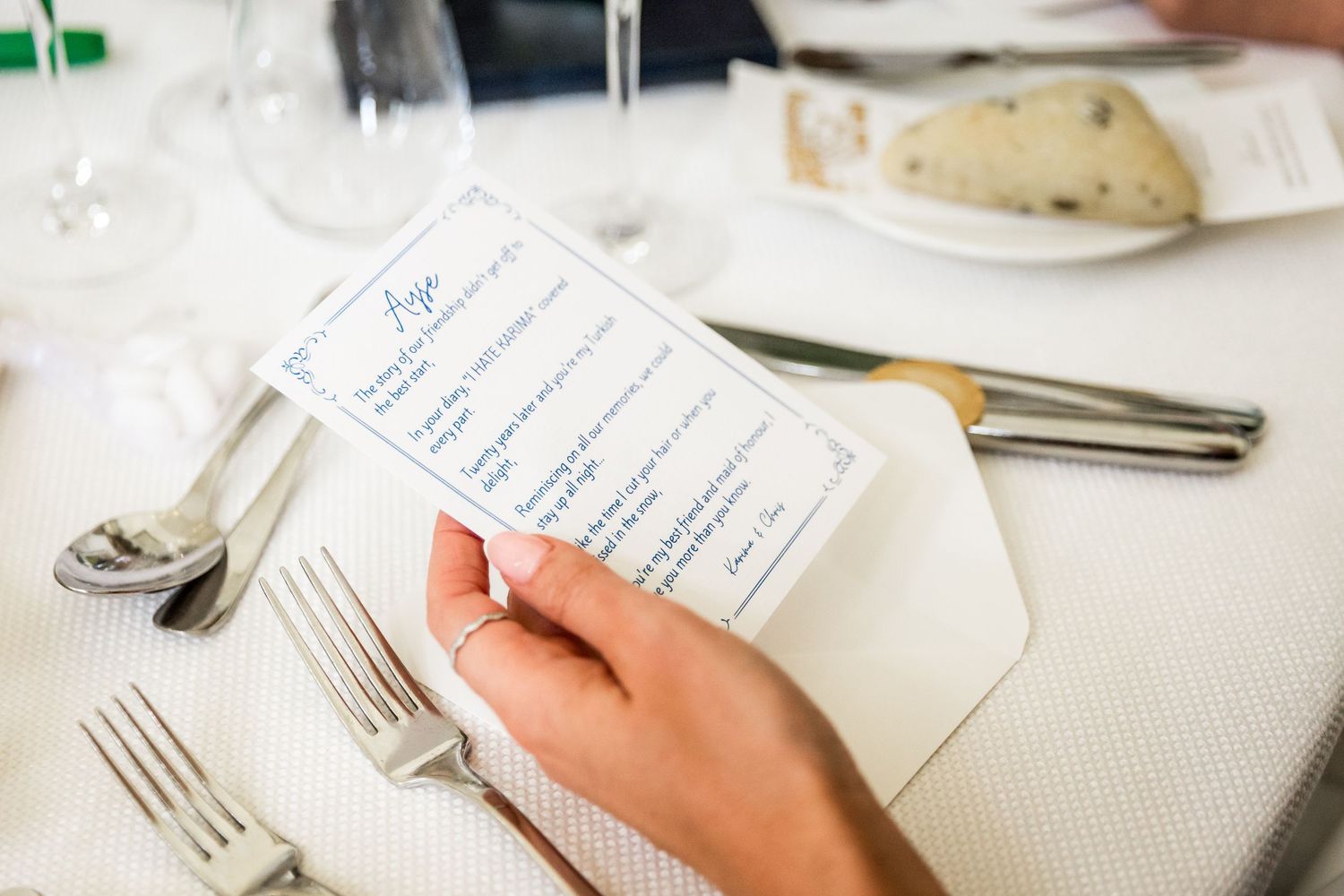 Guests reading handwritten notes or menus at an elegant wedding reception table.
