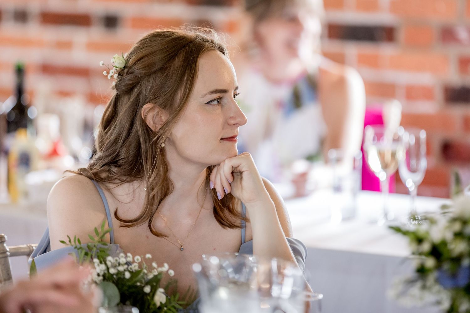 Wedding reception detail showing elegant table settings in rustic brick venue.