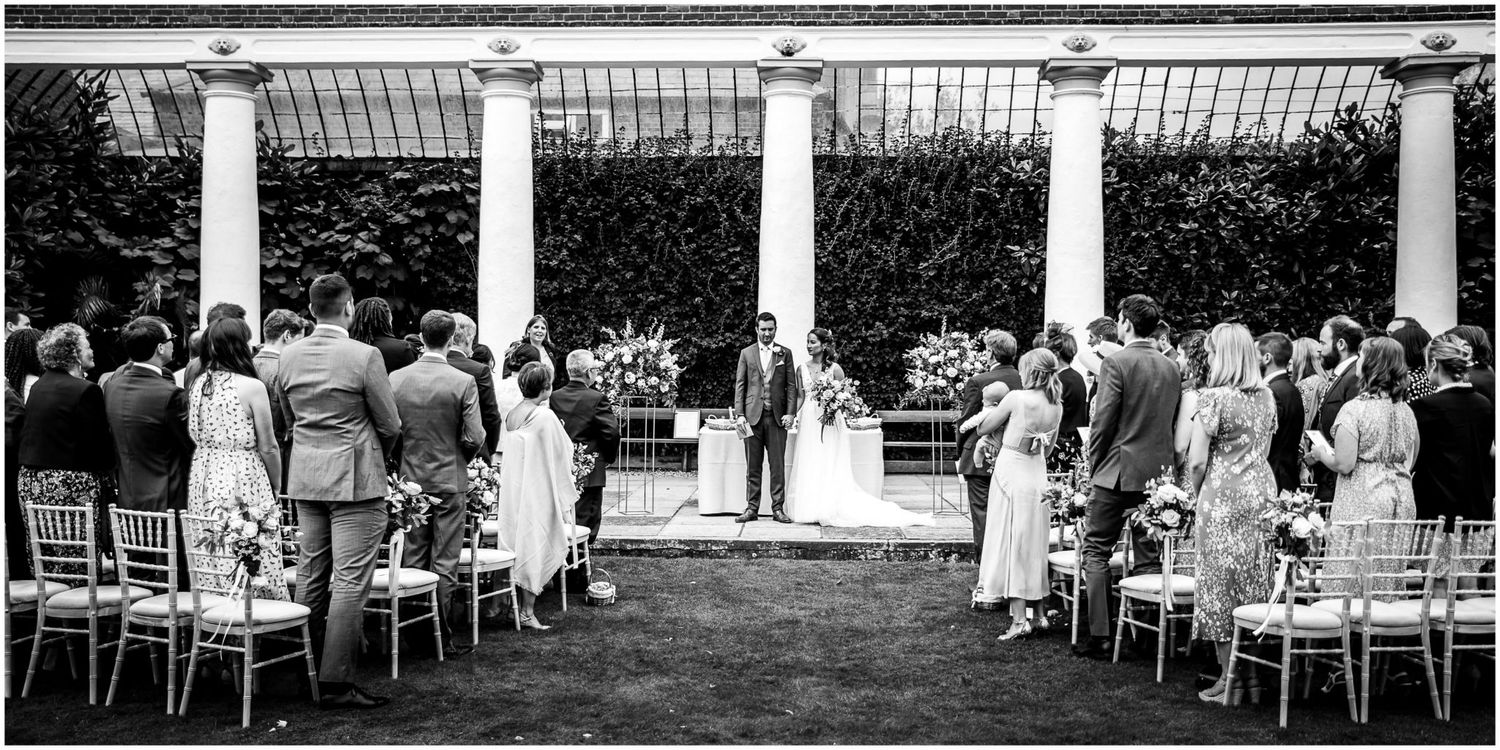 Wedding ceremony seating arrangement with elegant white chairs outdoors.