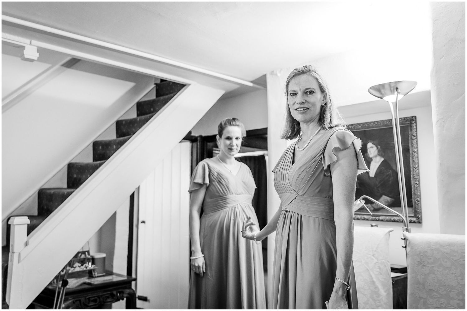 Wedding party getting ready in a bright room with white walls and natural lighting.