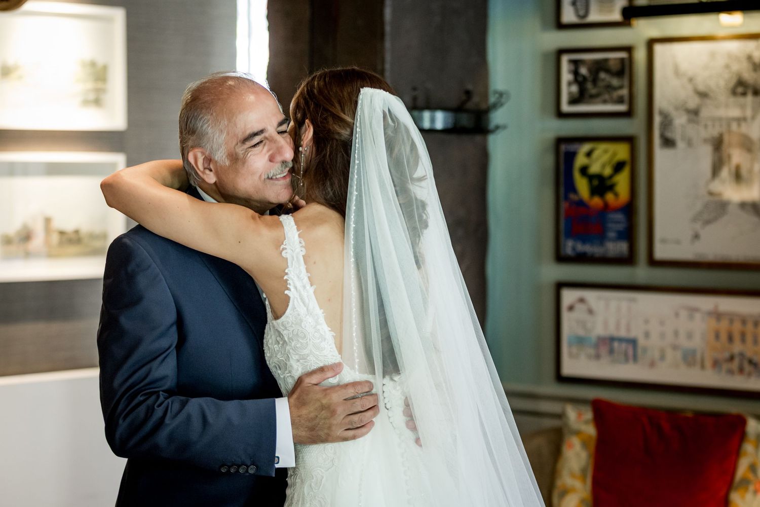 Touching father-daughter embrace before wedding ceremony in vintage-decorated room.