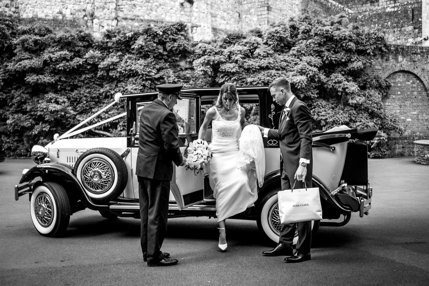 Series of black and white wedding photos featuring vintage car outside cathedral.