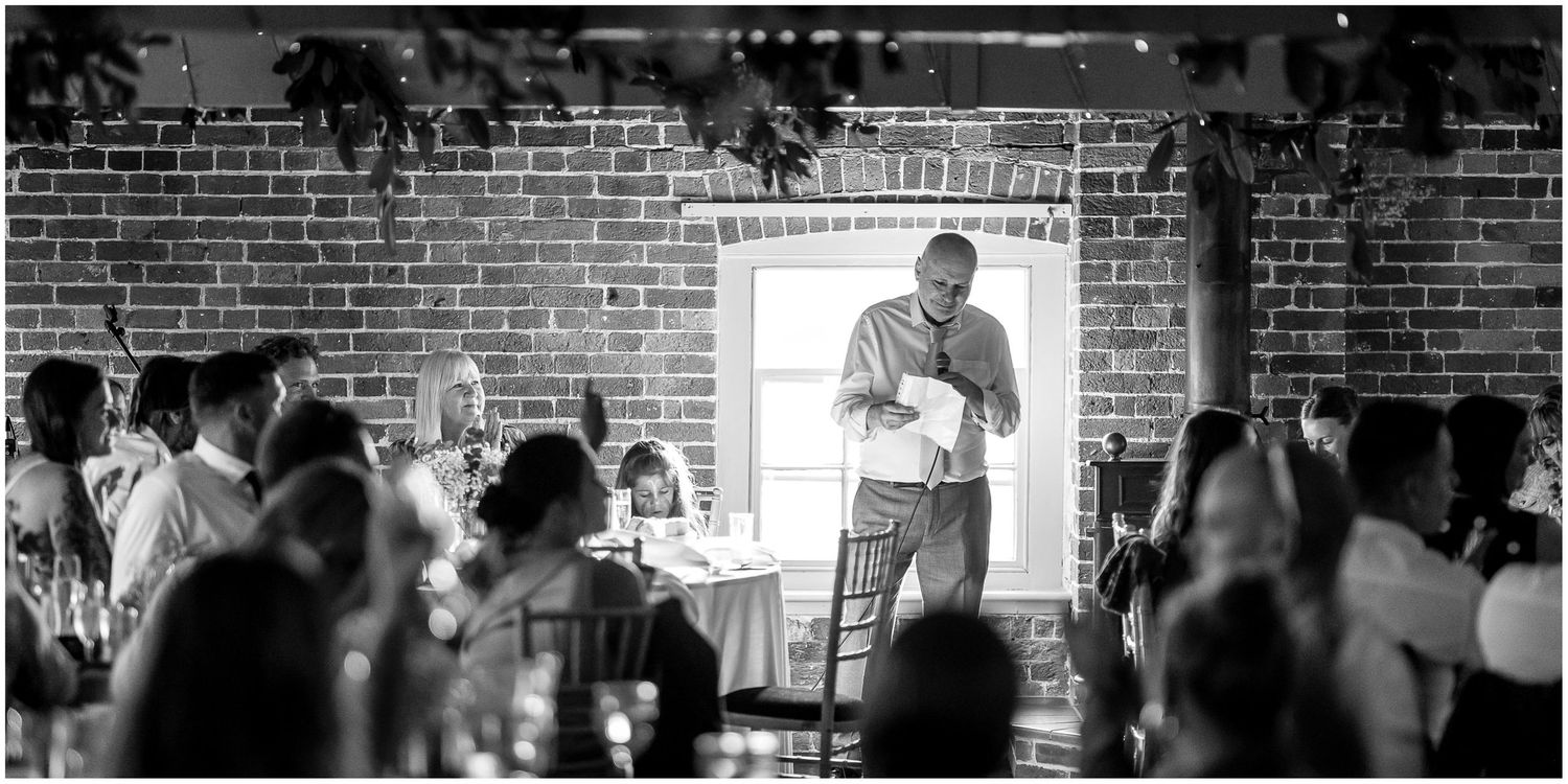 Atmospheric reception venue with brick walls and ambient lighting.