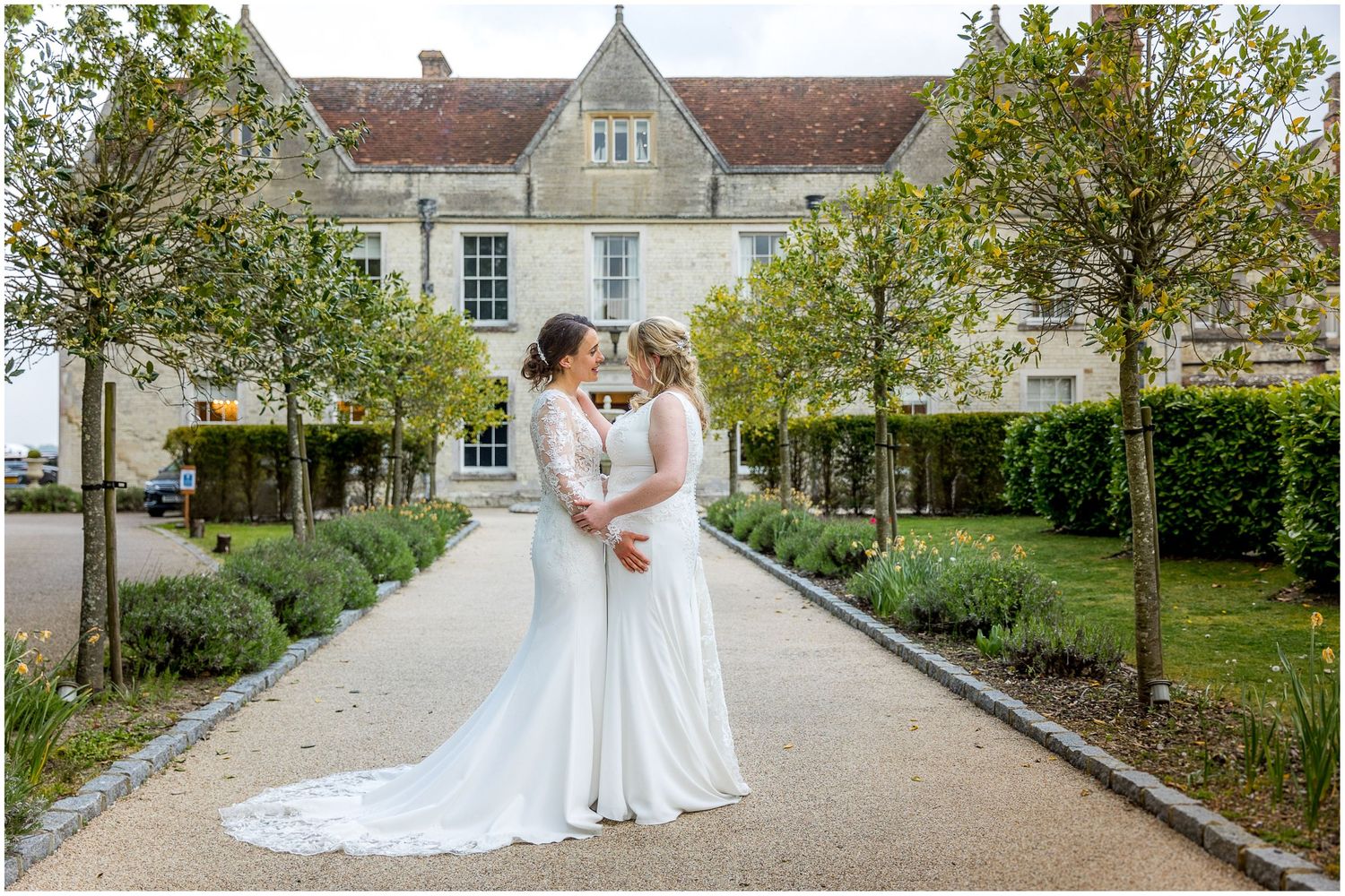 Beautiful manor house serves as backdrop for wedding photos on manicured grounds.