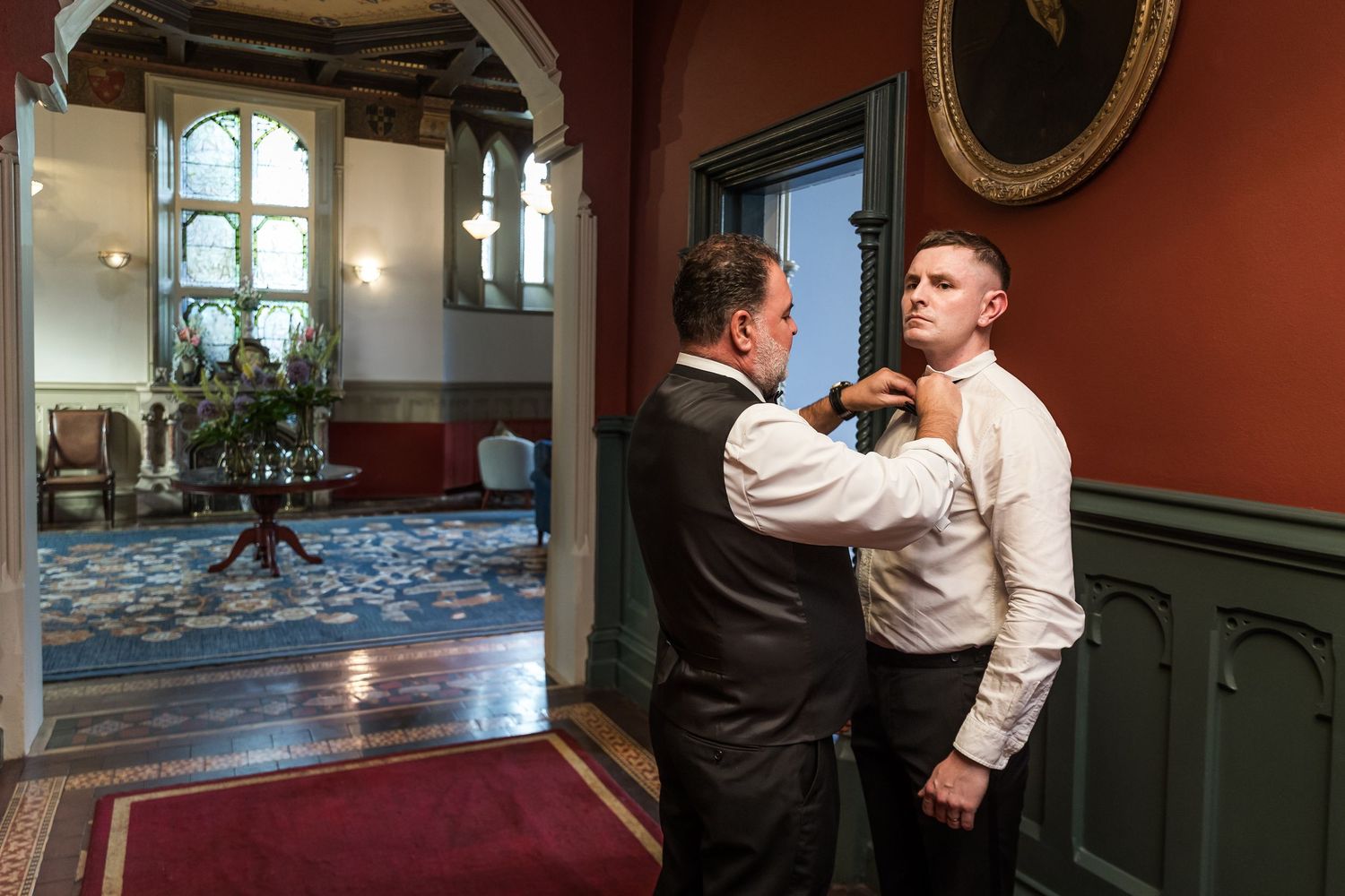 Interior wedding photograph of The Elvetham as a groom finishes getting ready before the marriage ceremony