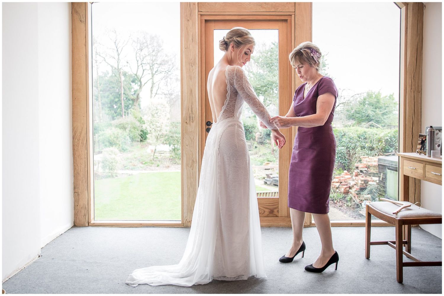 Natural light streams through windows as wedding preparations take place in an elegant room.