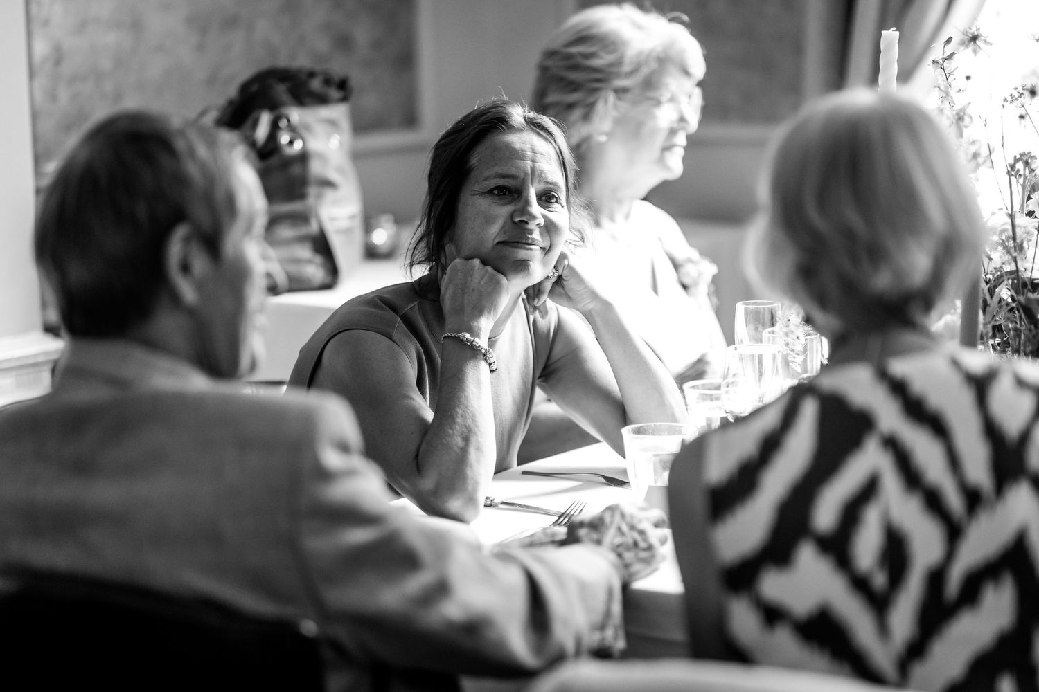 Wedding guests engaged in lively conversation at an elegant reception dinner.