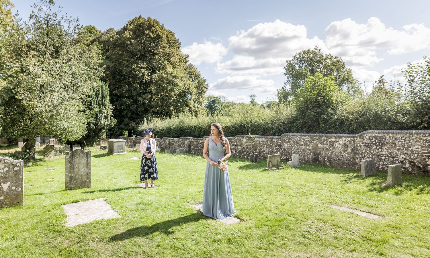 Scenic view of an English countryside church and cemetery on a sunny summer day.