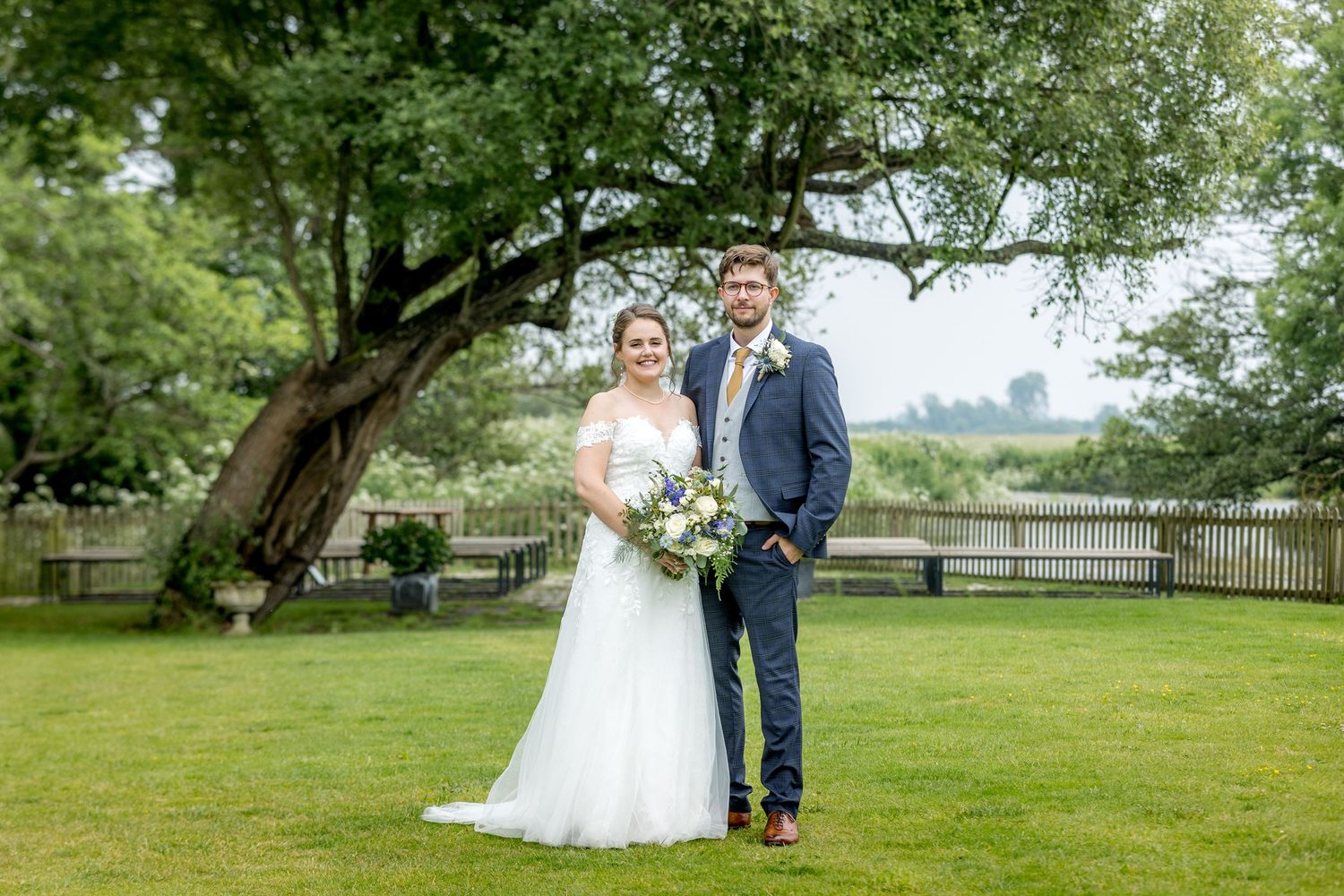 Wedding couple poses for photos in a scenic garden setting.