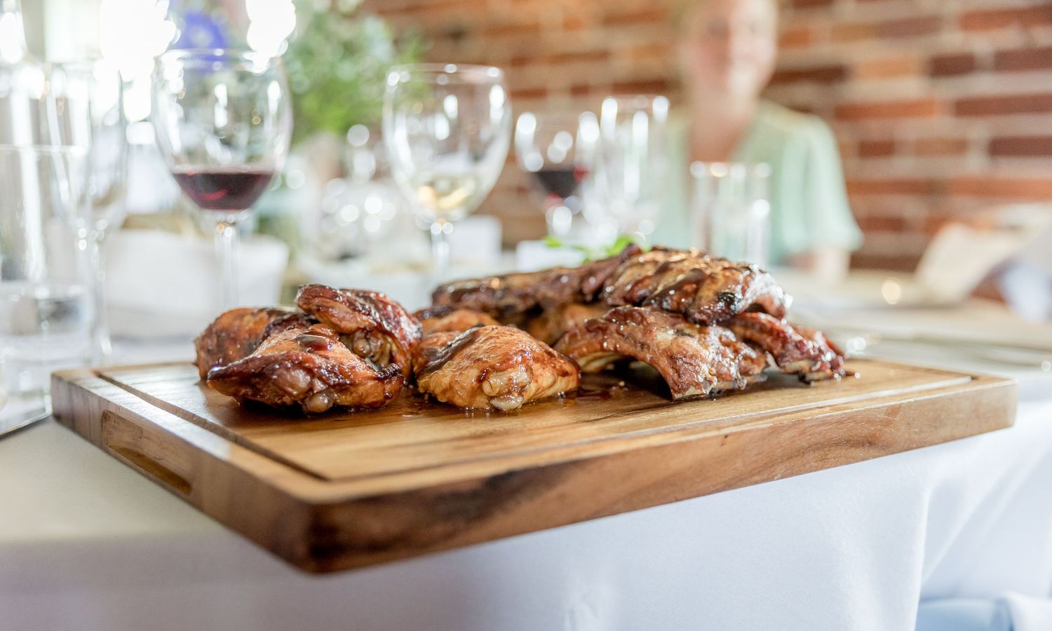Grilled meats served on wooden cutting boards at an elegant wedding reception.