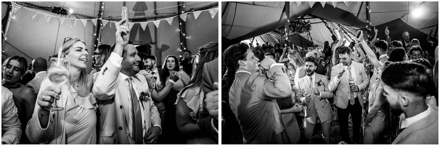 Black and white wedding reception photo showing guests dancing and celebrating joyfully under a festive tent.