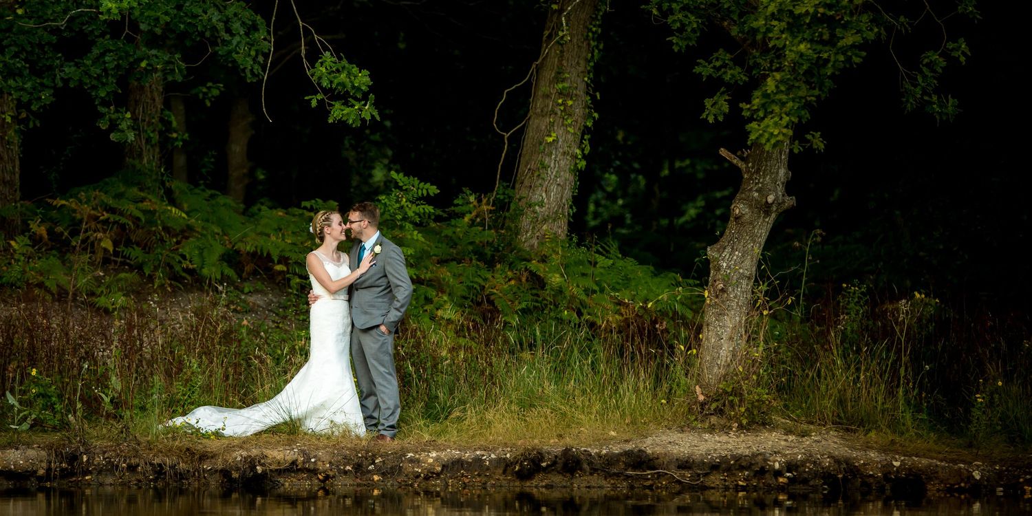 Wedding couple shares intimate moment in wooded natural setting.
