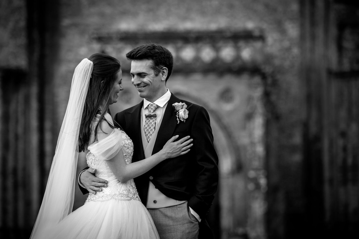 Black and white portrait of newlyweds sharing an intimate moment.