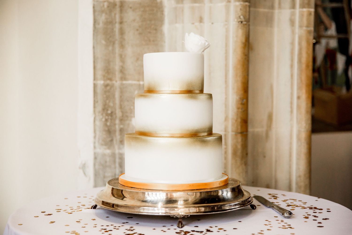 Elegant white wedding cake displayed on a decorative silver stand.