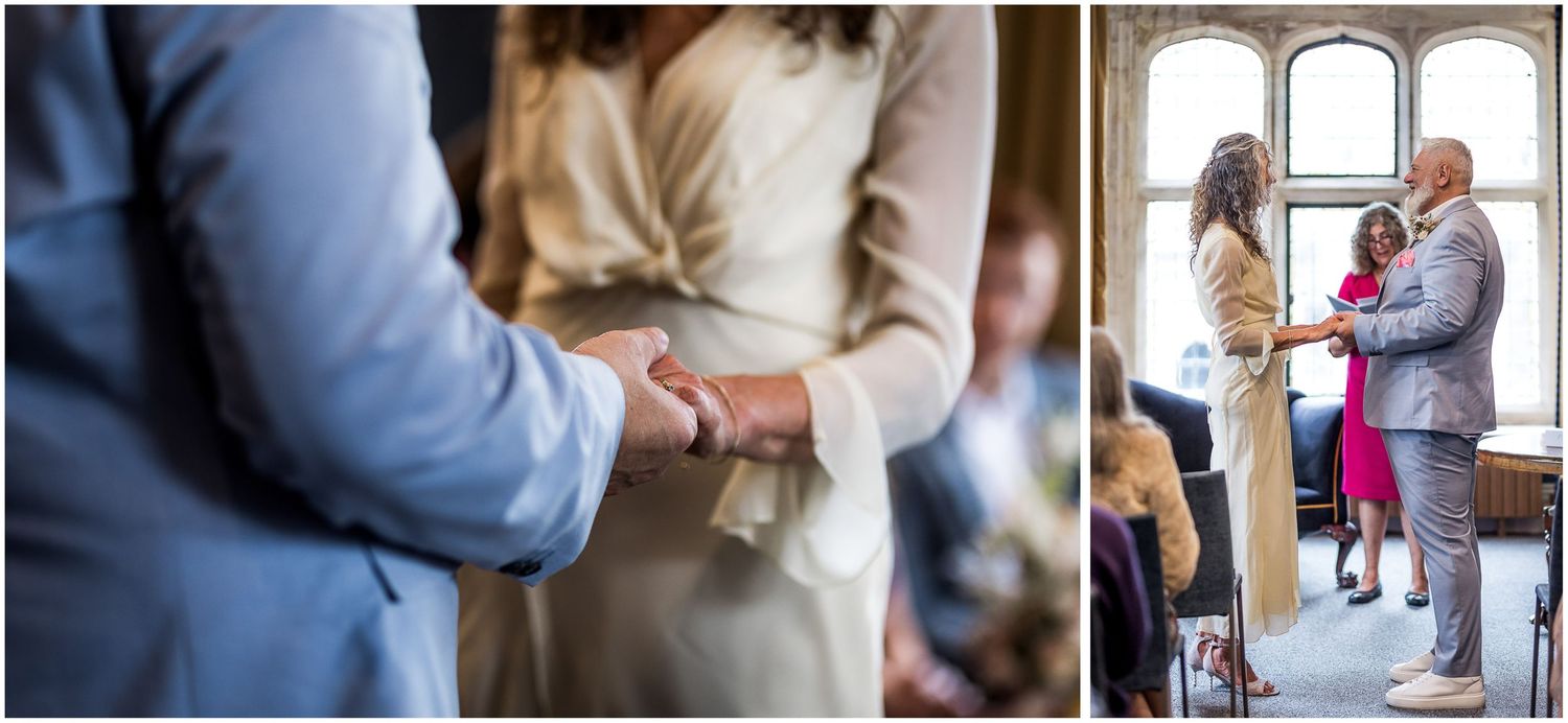 Bride and groom holding hands to make their vows in front of the window in the Castle Room at Winchester registry office