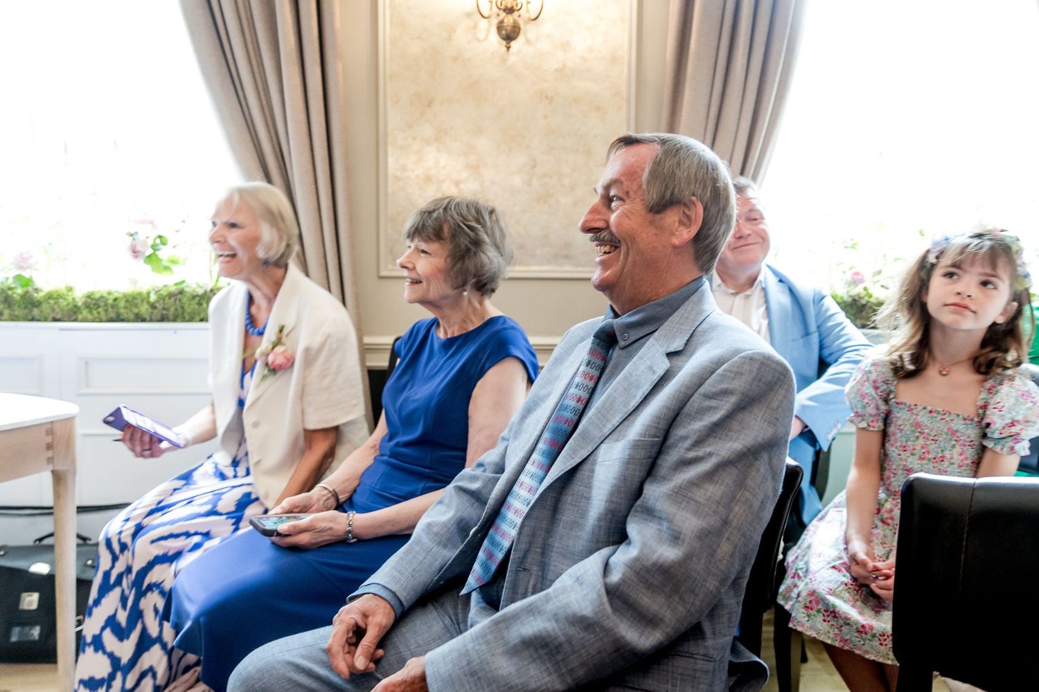Wedding guests seated in rows during an indoor ceremony.