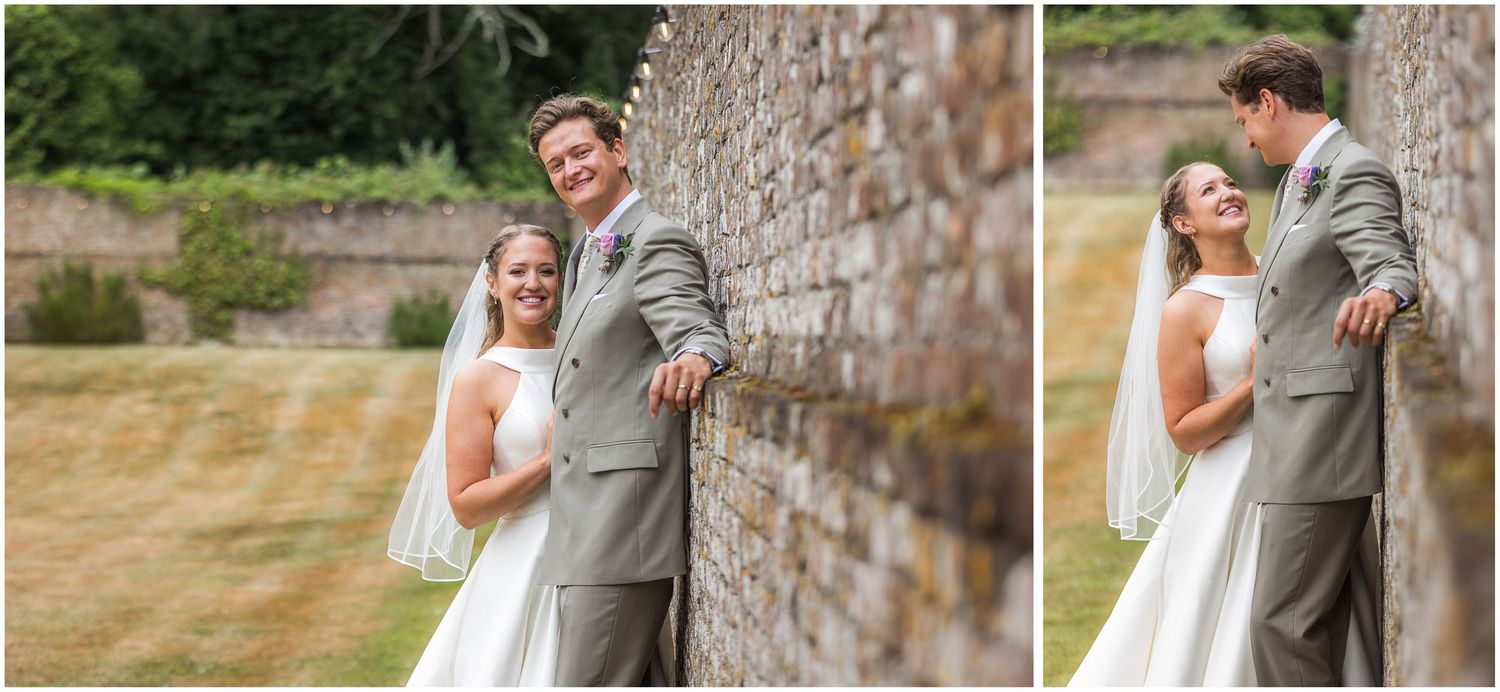 Couple wedding portraits posed against the wall of the garden reception venue he Hampshire's Holywell Estate
