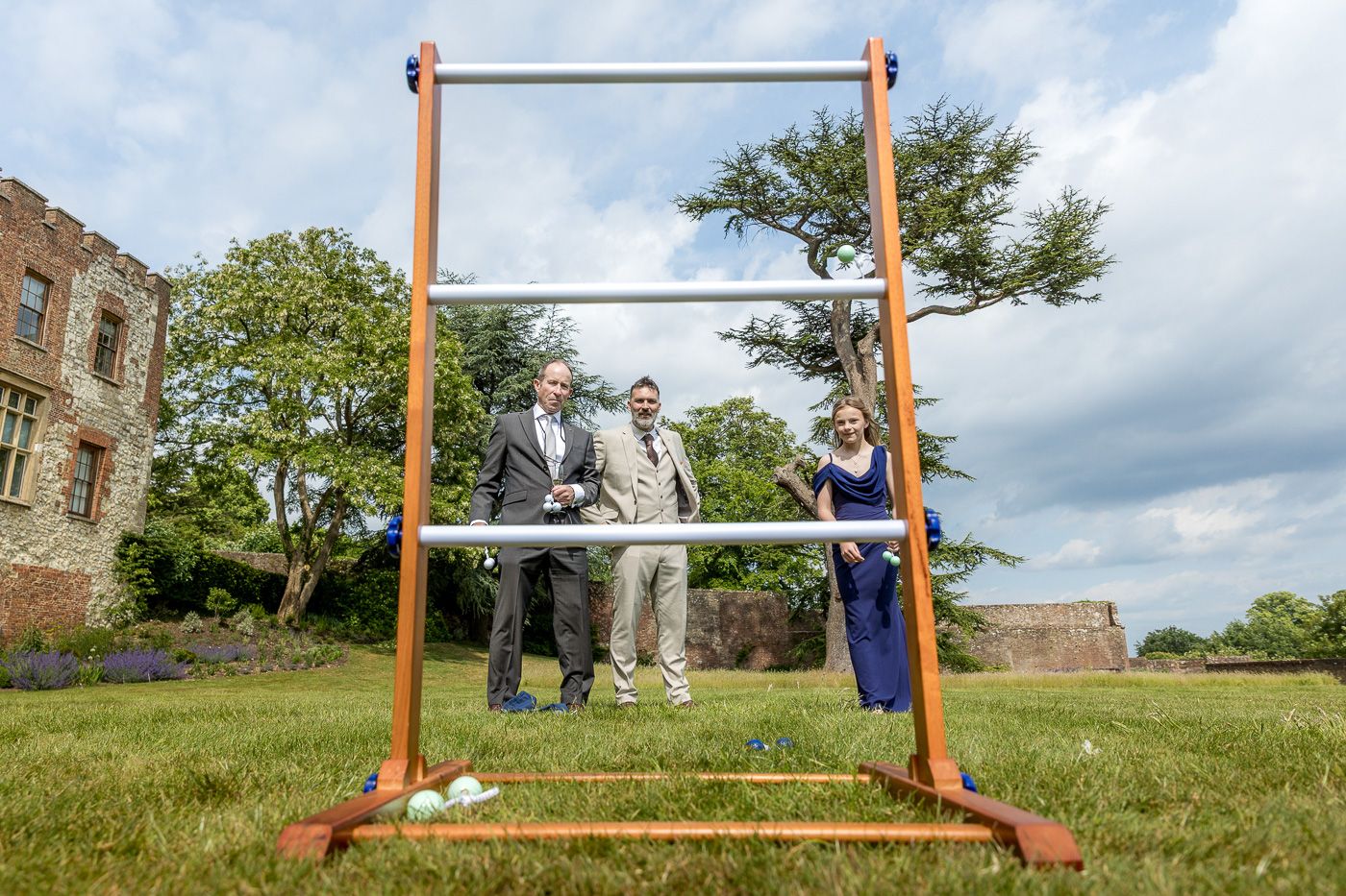 Outdoor wedding setup with wooden arch against cloudy sky in rustic setting.