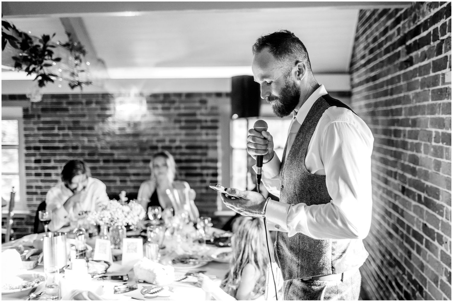 Reception dinner setting with exposed brick walls and natural lighting.