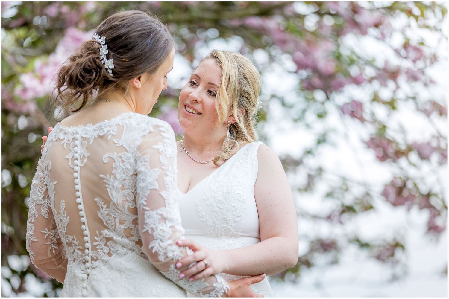 Spring wedding portraits with blooming cherry blossoms in background.