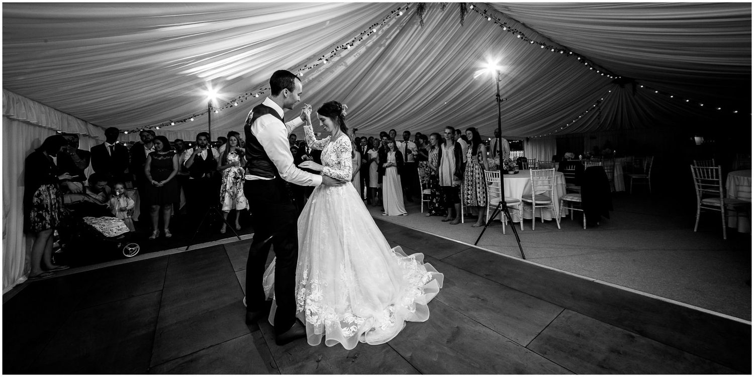 Black and white wedding photos showing couples dancing and celebrating at an elegant reception under draped fabric ceiling.
