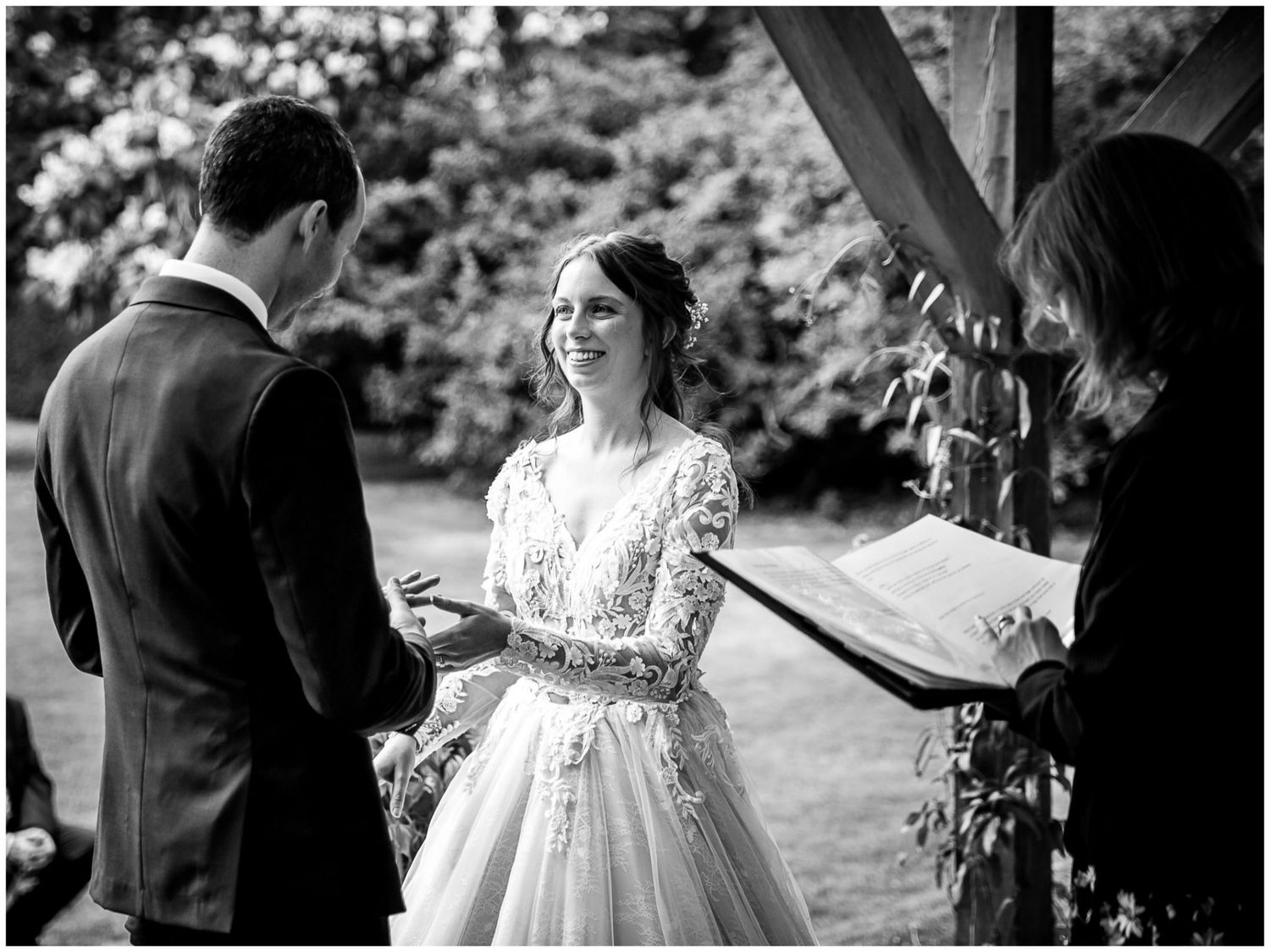 A series of black and white wedding photos showing intimate moments during an outdoor garden ceremony.