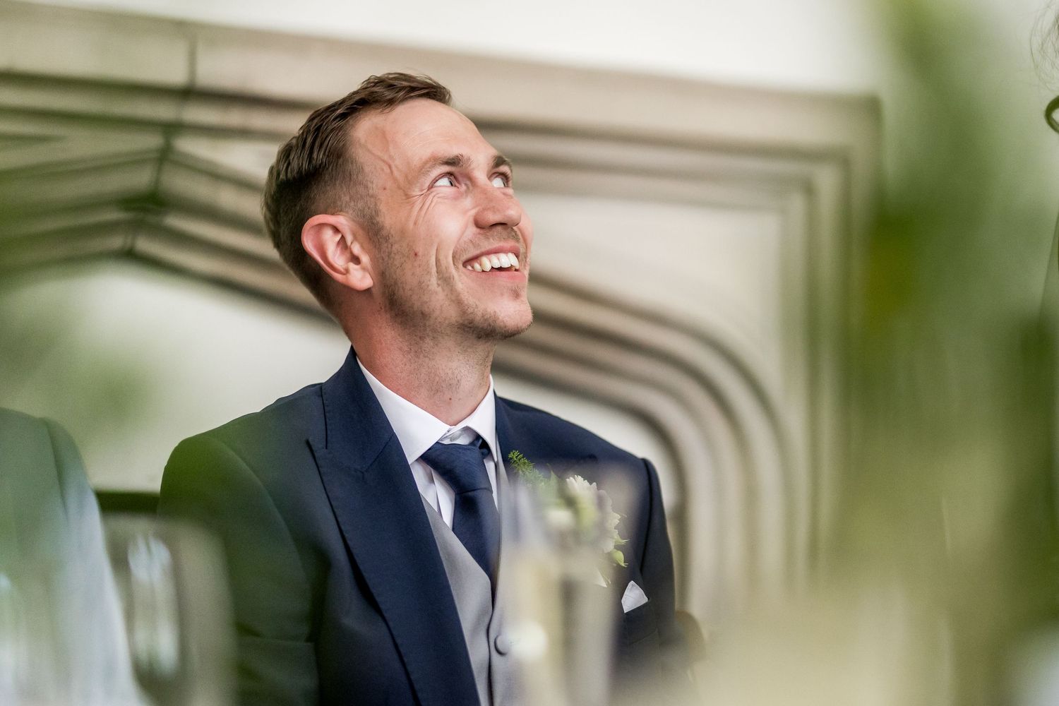Wedding guests enjoying speeches and moments during an indoor reception.