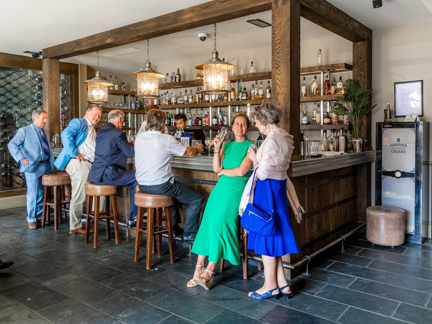 Rustic bar interior with wooden beams and modern lighting fixtures.