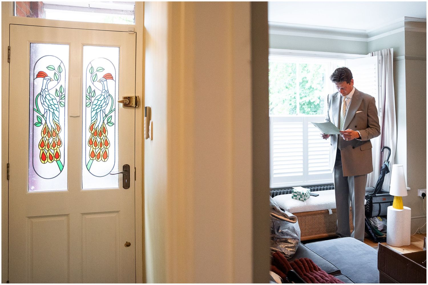 The groom reads a card from his bride as the wedding party get ready at home