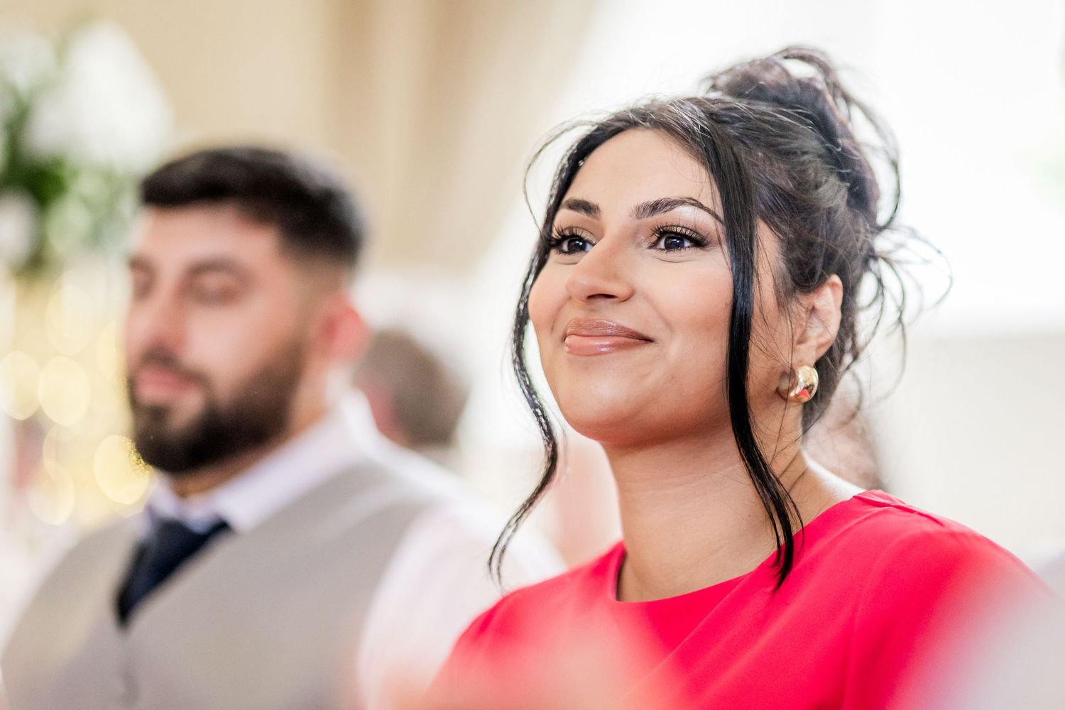 Wedding guests sharing joyful moments during an indoor reception celebration.