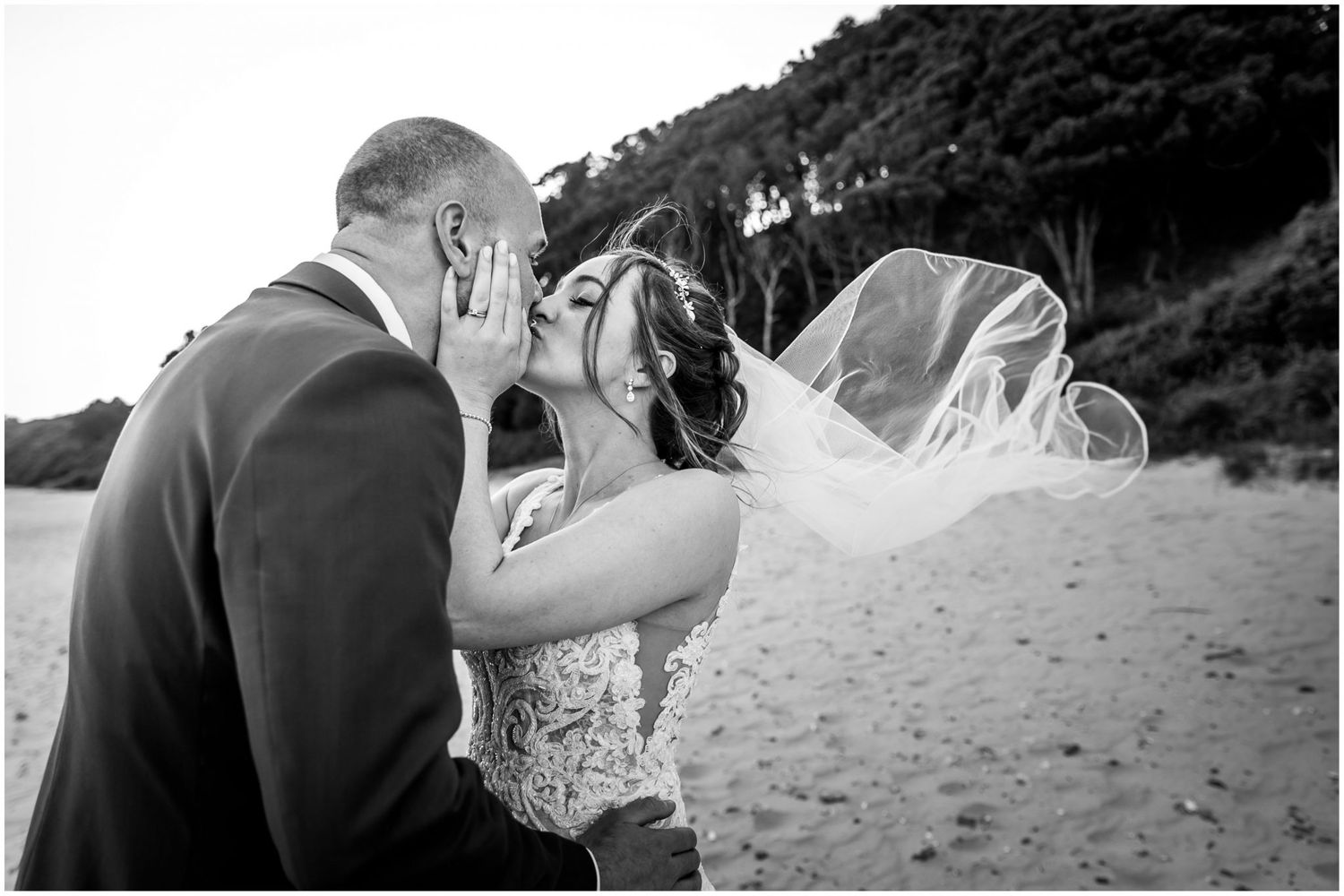 Black and white wedding portraits showing intimate moments between the couple on the beach.