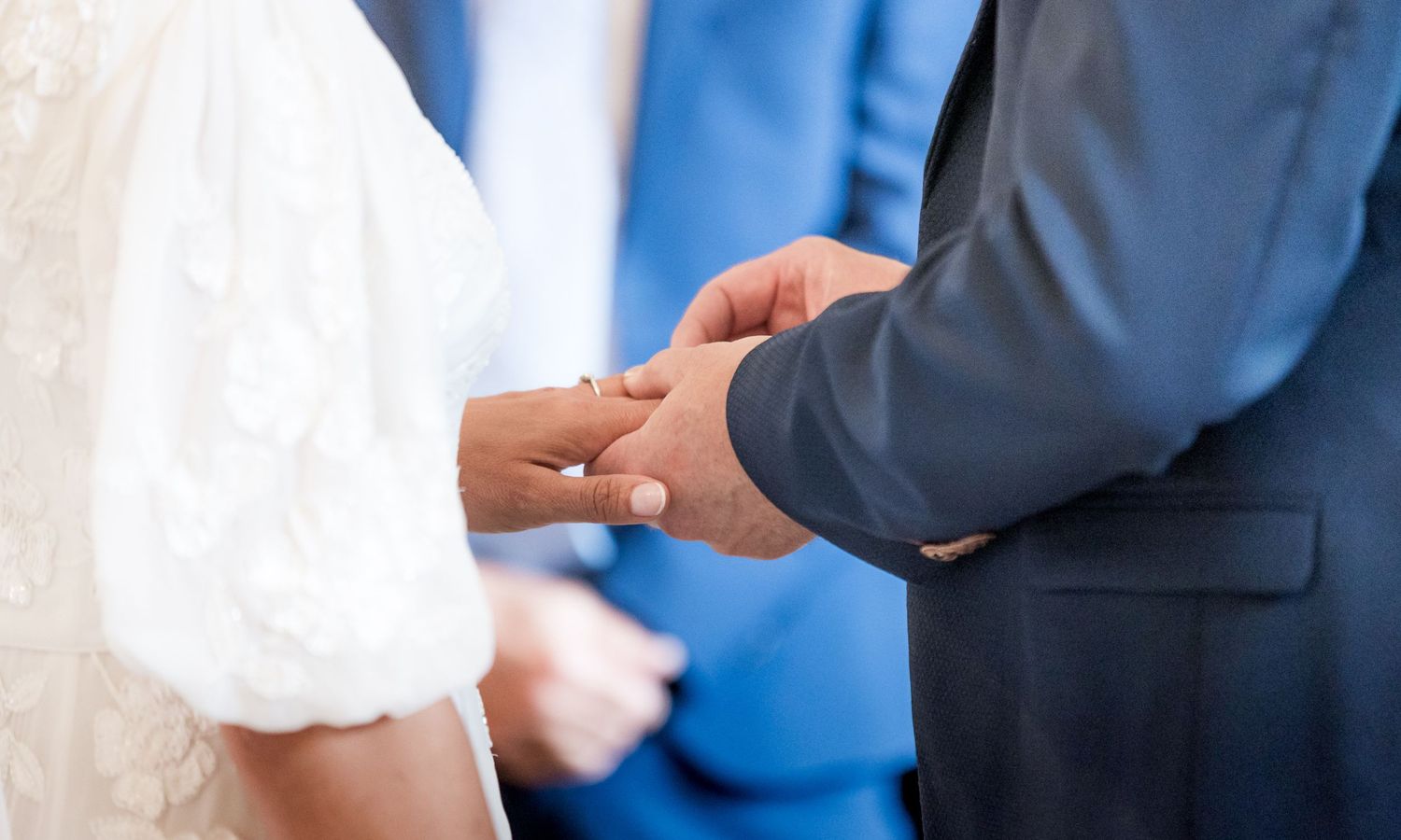 Close up of hands exchanging rings during a wedding ceremony.