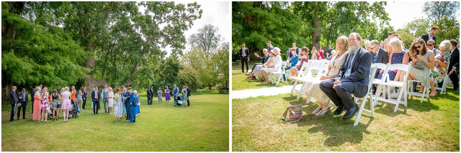 A group of wedding guests gather outdoors for a celebration in a lush green garden setting.