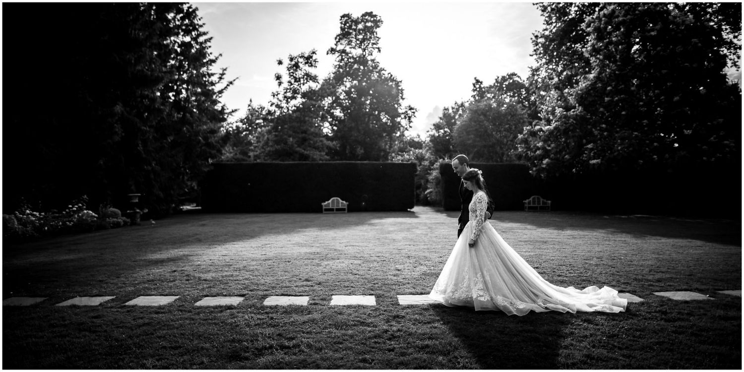 A romantic couple walks through a scenic park pathway during a golden sunset moment.