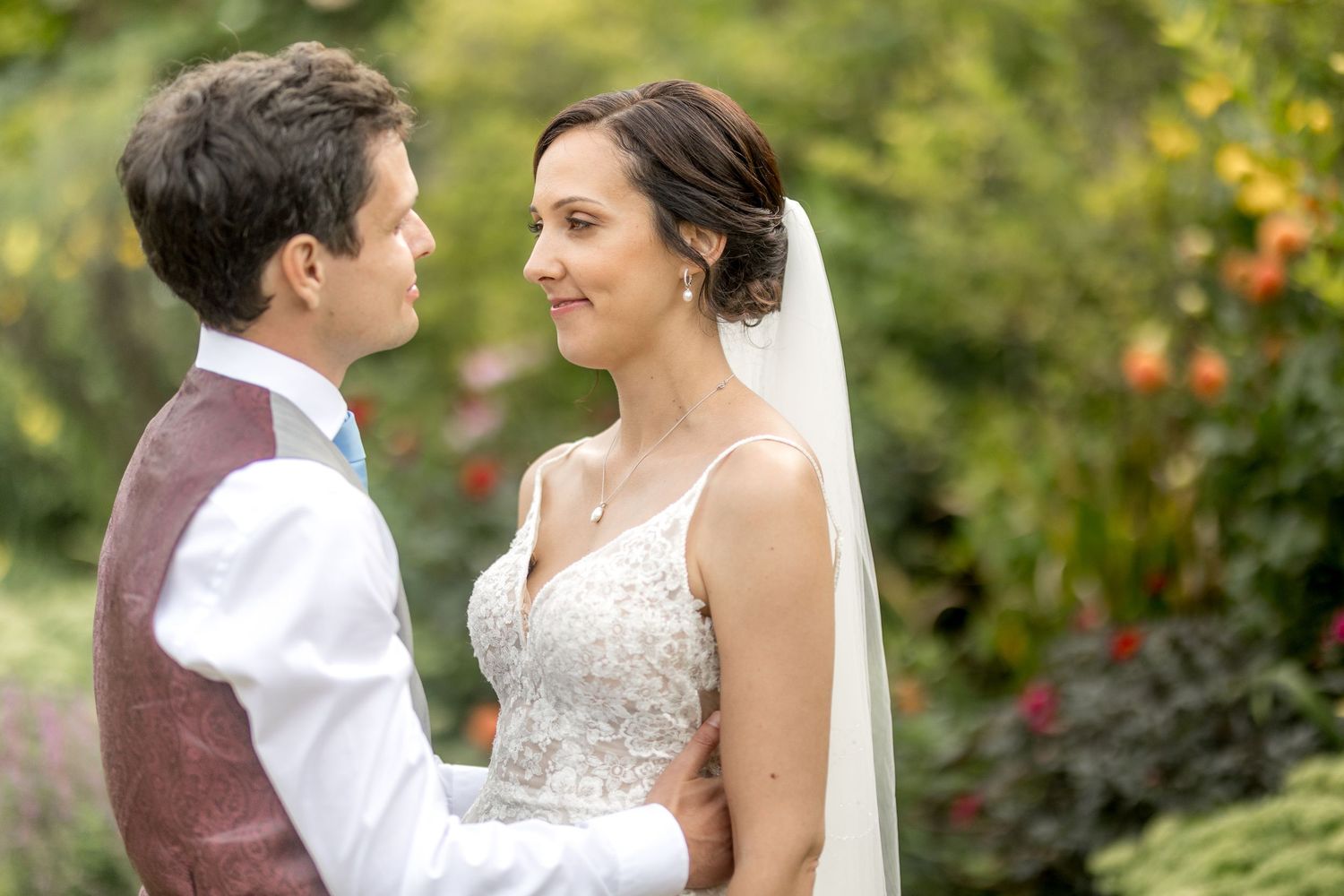 Wedding couple sharing intimate moments in a beautiful outdoor garden setting.