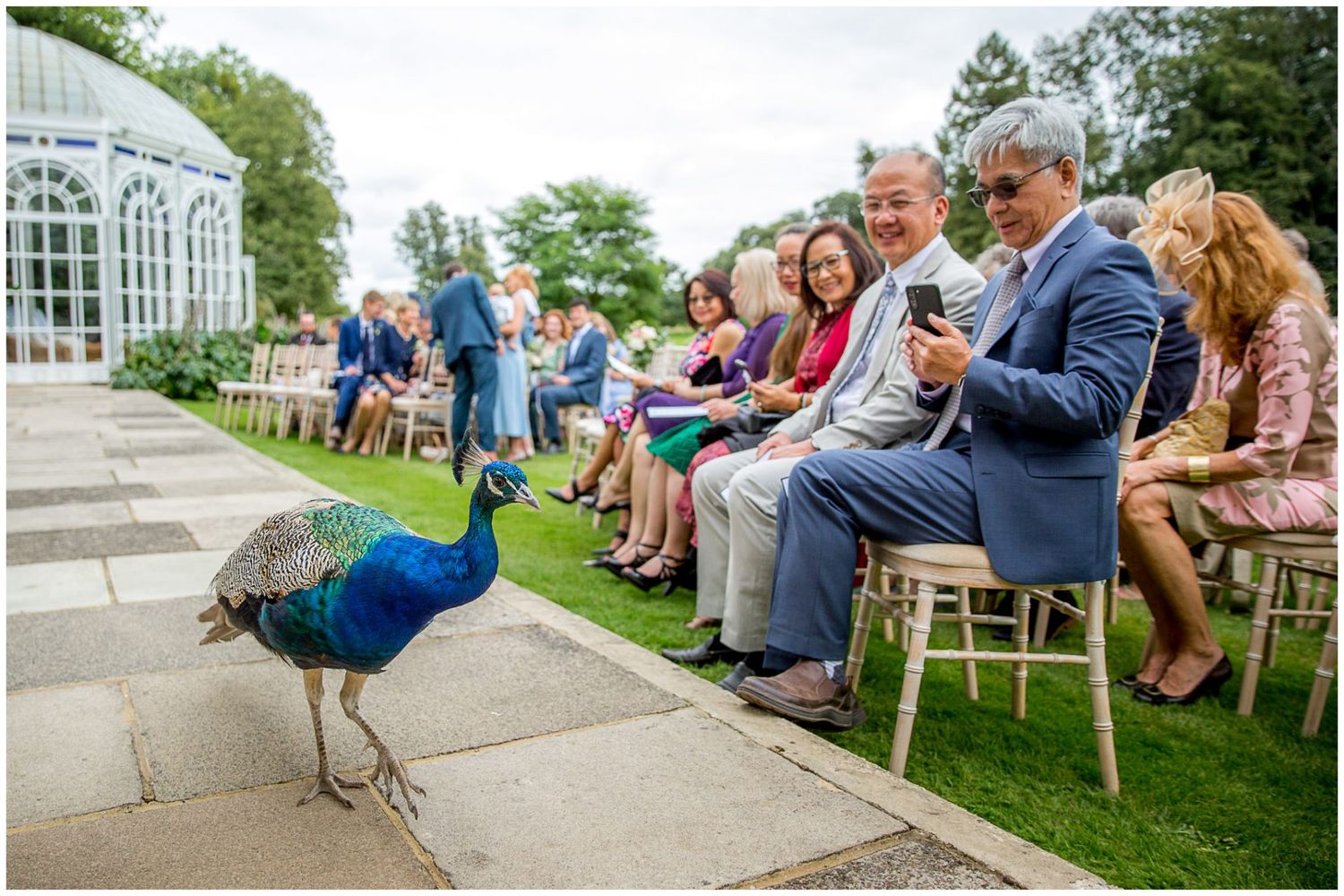 Guests enjoy outdoor wedding reception seating on garden terrace.