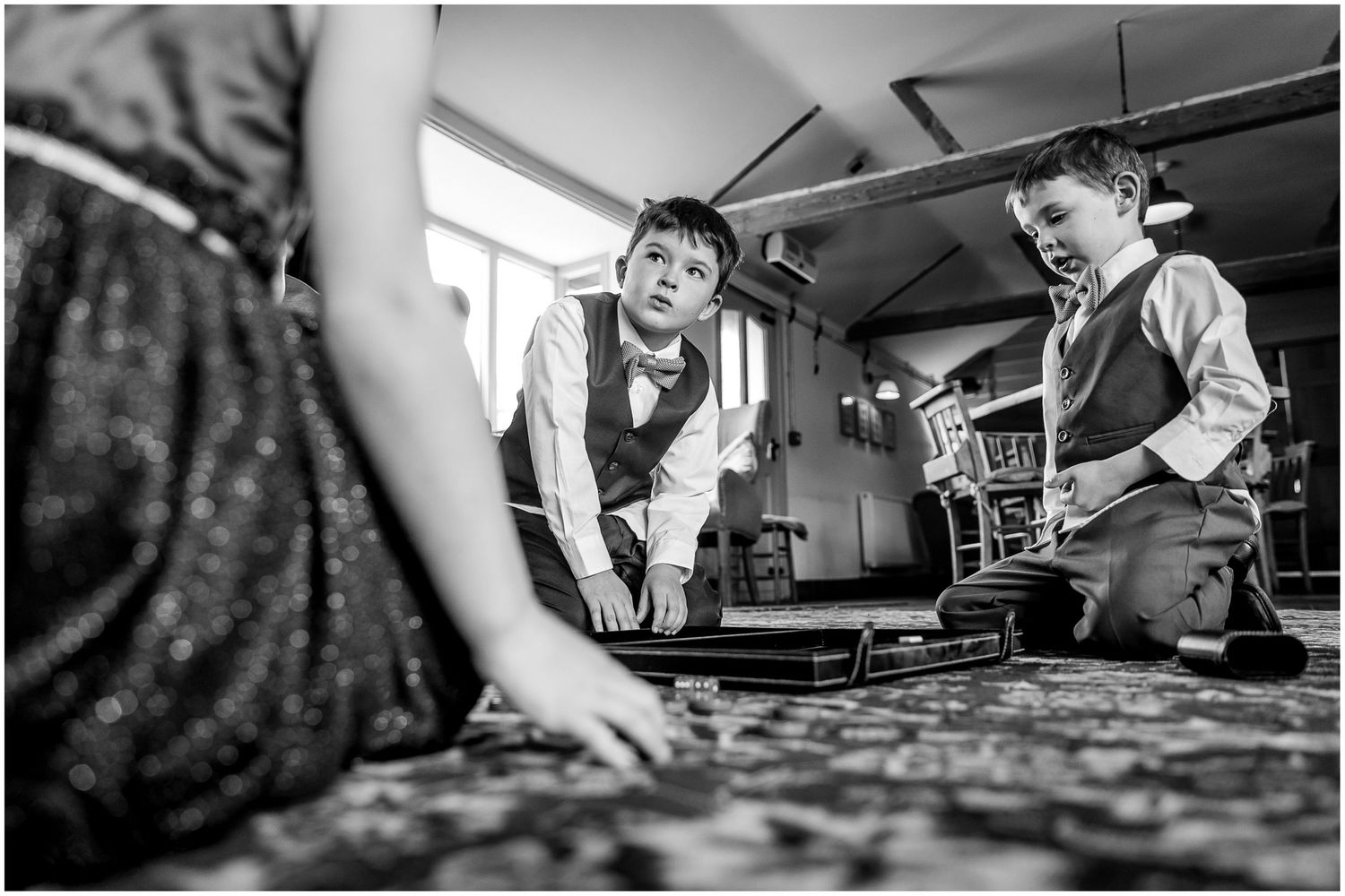 Two people in formal attire leaning over a table engaged in what appears to be a game or activity.