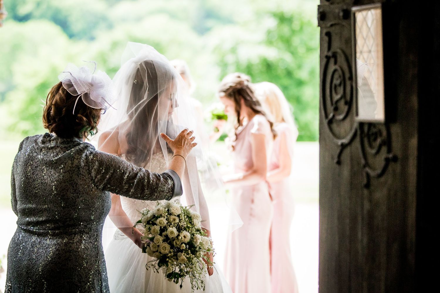 Wedding couple standing in doorway with soft natural light streaming through.