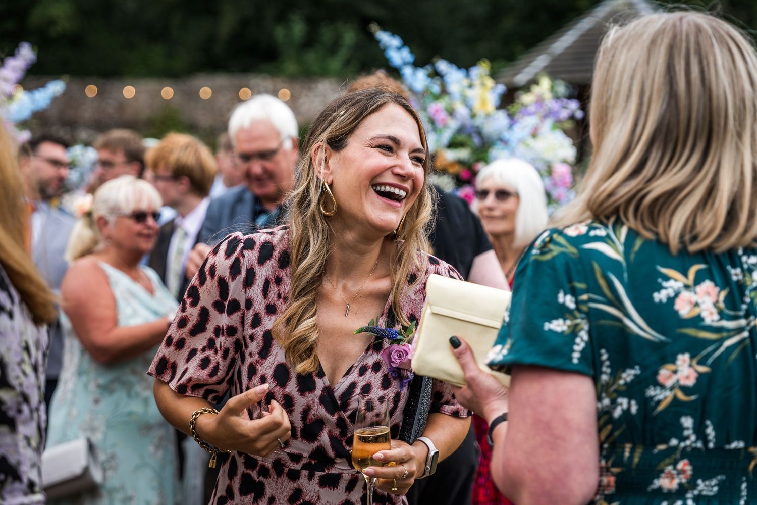 Joyful celebration with guests laughing and mingling at an outdoor party.