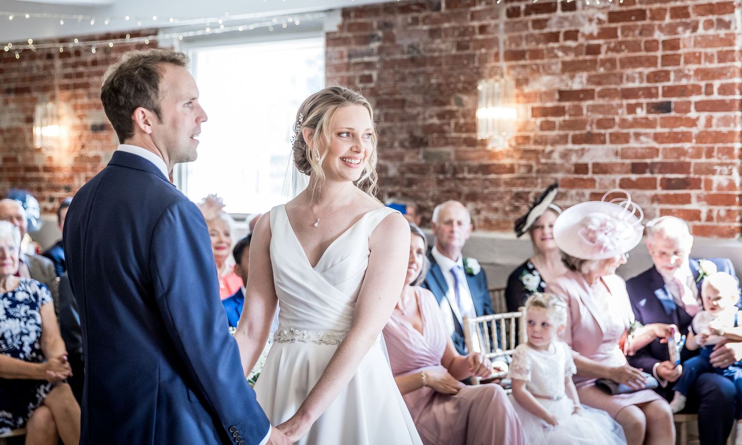 Wedding reception in a rustic brick venue with guests enjoying the celebration.