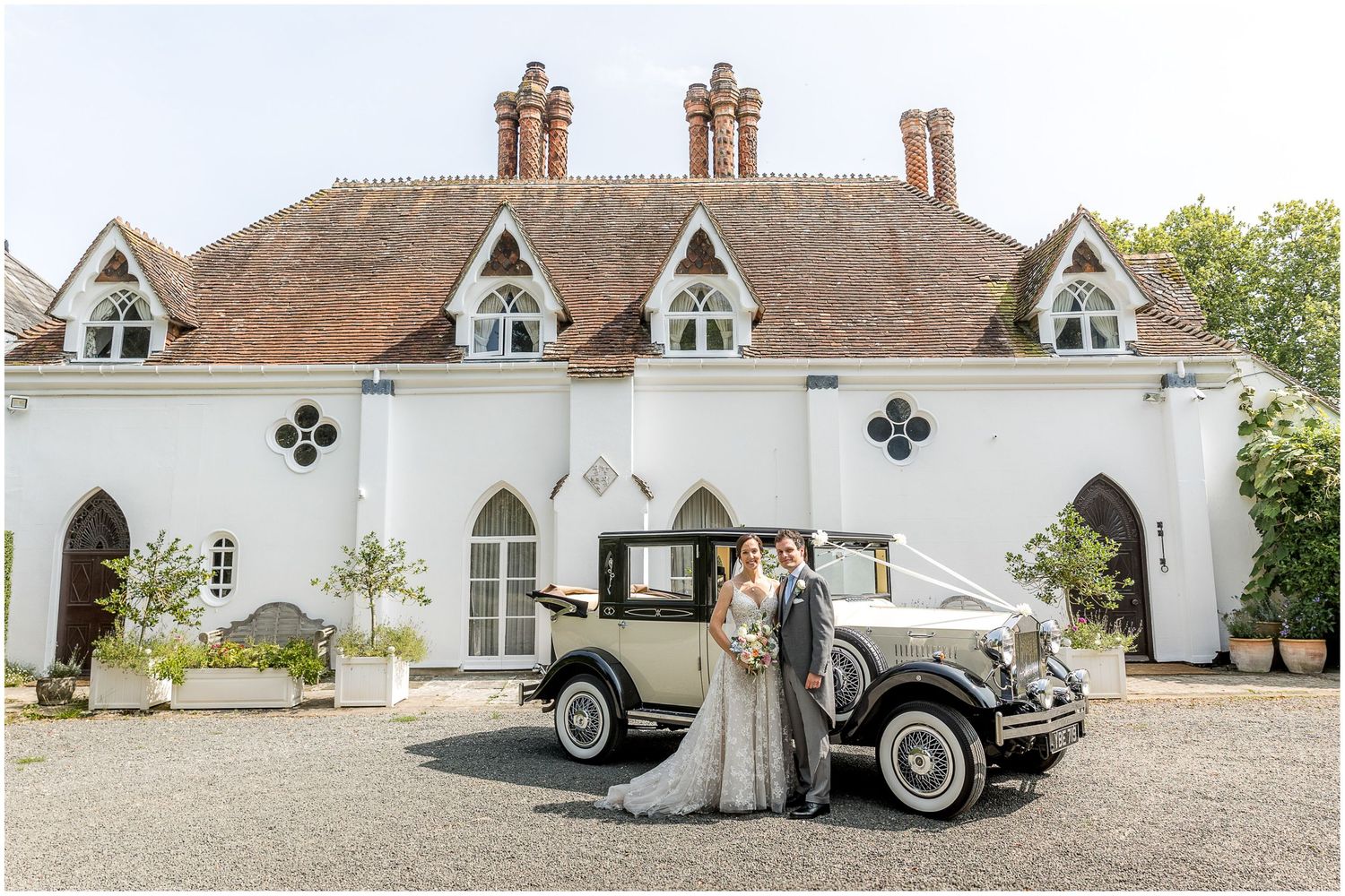 Beautiful wedding venue exterior with classic car and Tudor-style architecture.
