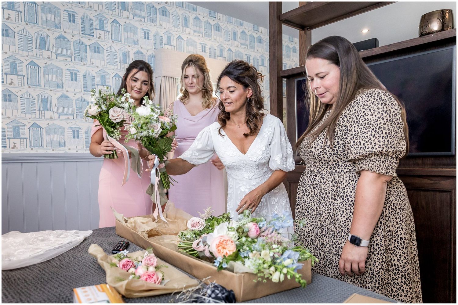 Wedding party arranging floral decorations on a wooden table.