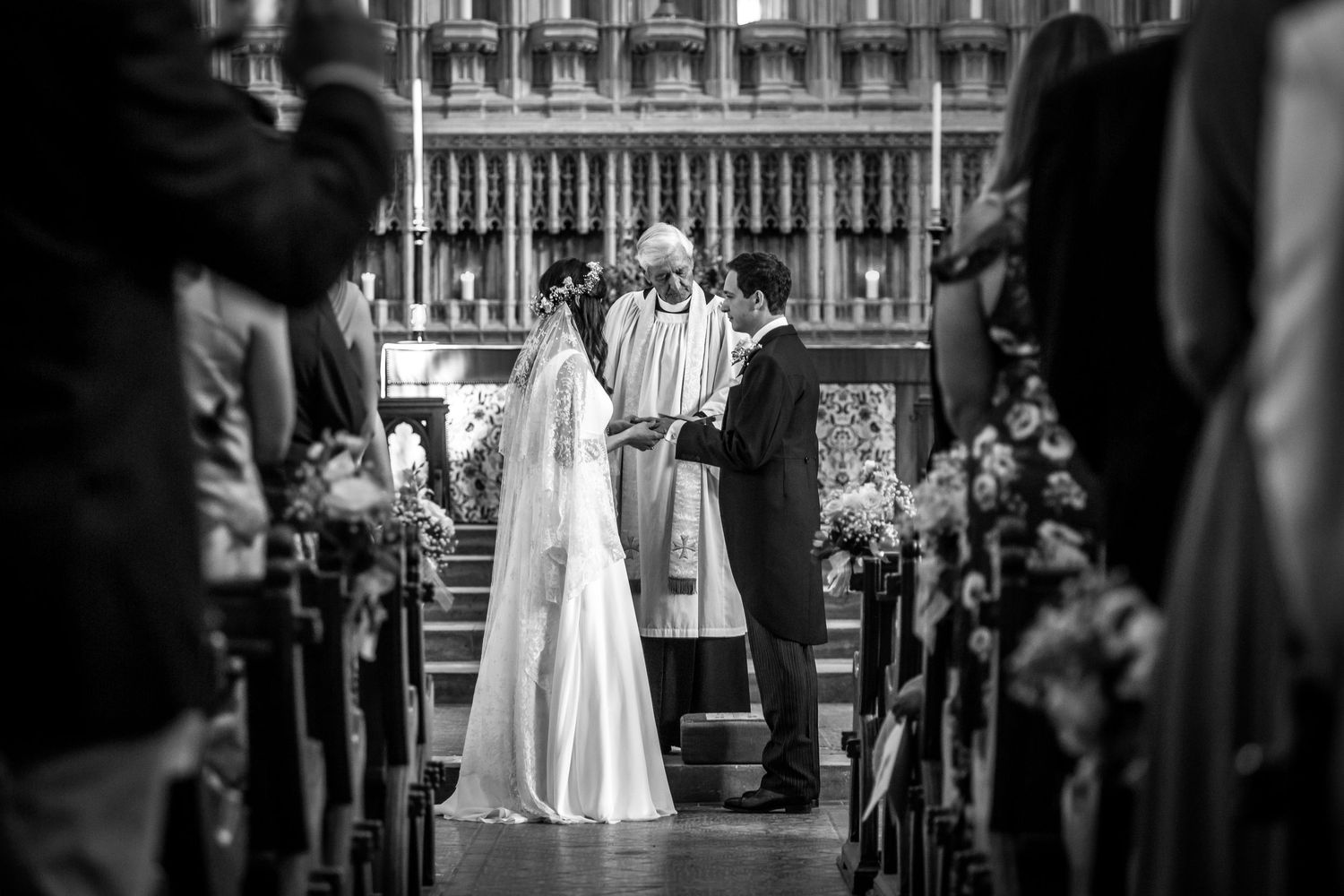Black and white wedding photograph with a bride and groom making their vows at Milton Abbey School in Dorset