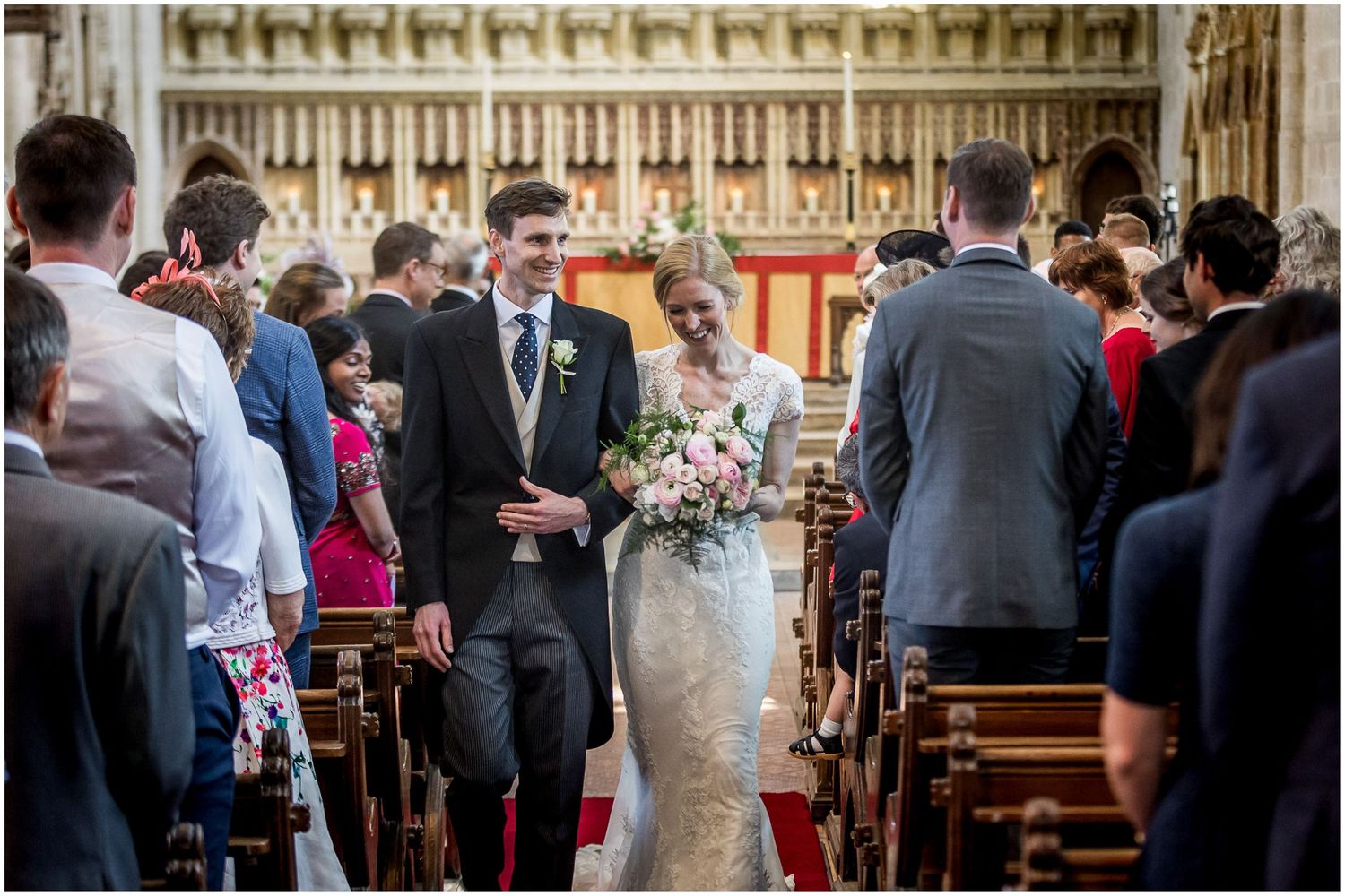 Bride and groom walk down the aisle together at the end of their wedding ceremony at Milton Abbey in Dorset