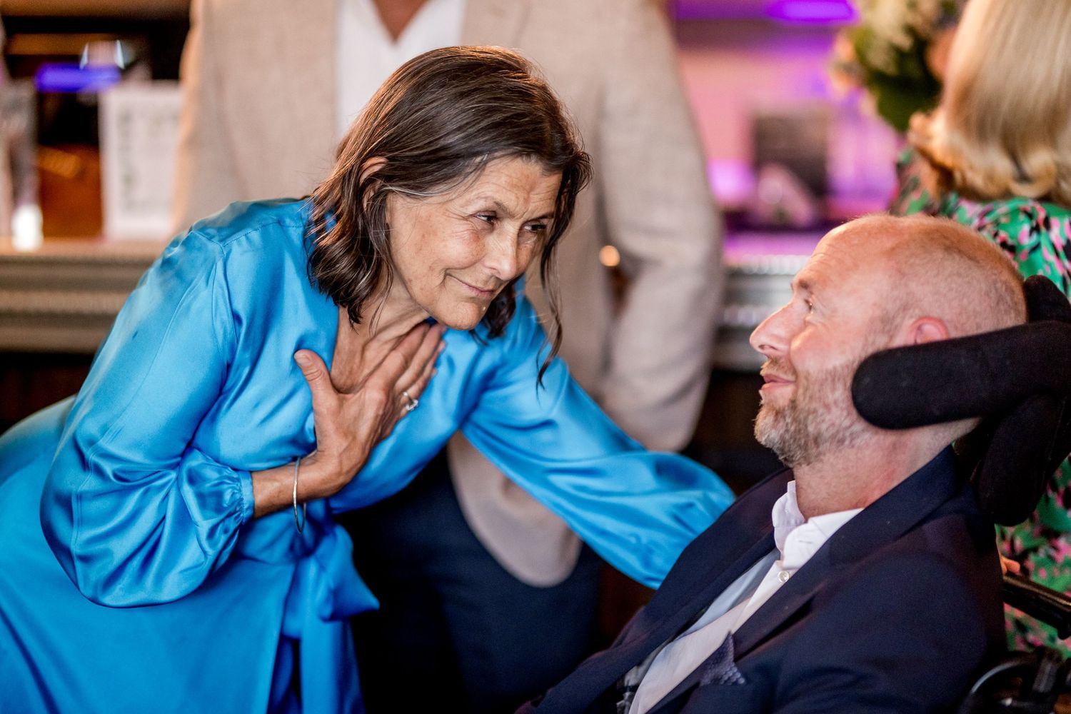Guests engaged in animated conversation during an evening social event.