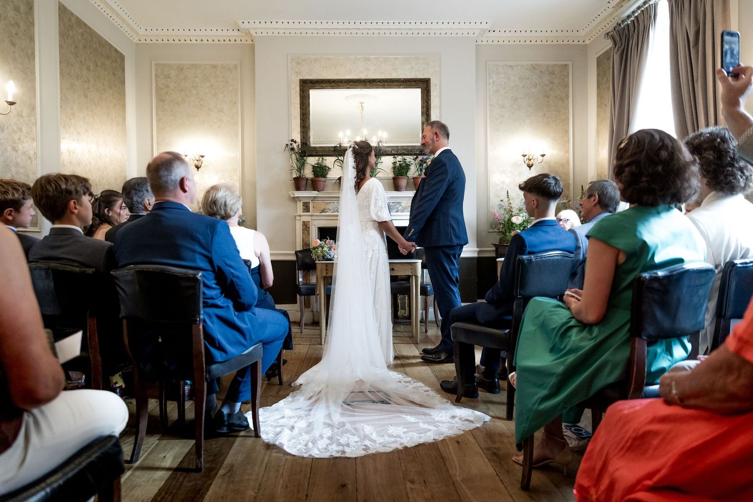 Wedding ceremony in progress with long train dress and guests in attendance.