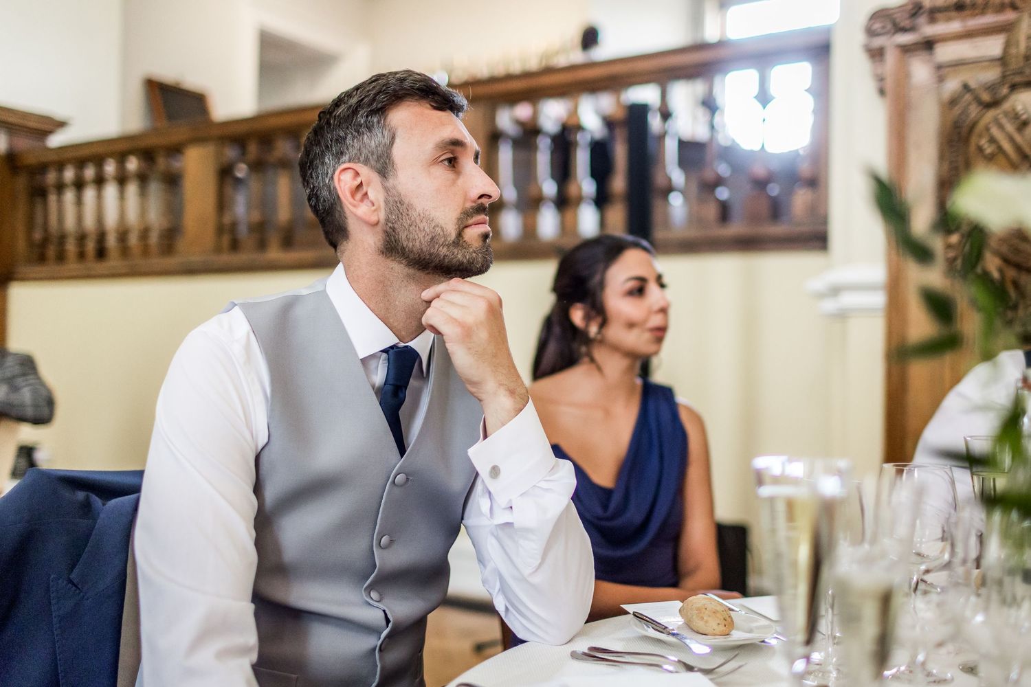 Wedding reception guests seated at tables in an elegant indoor venue with classic decor.