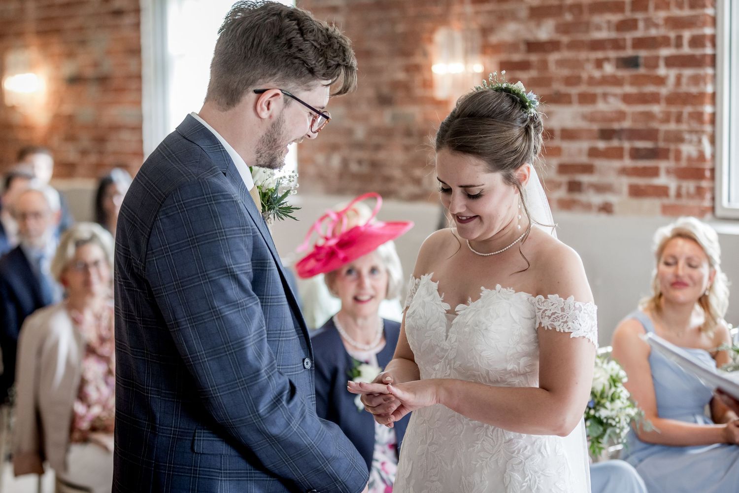 Wedding ceremony candid moments captured in a historic brick-walled venue.