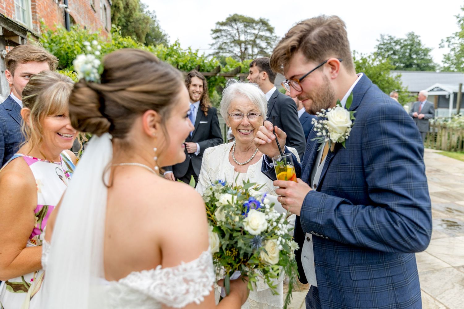 Wedding celebration candids showing guests enjoying themselves in a garden setting.